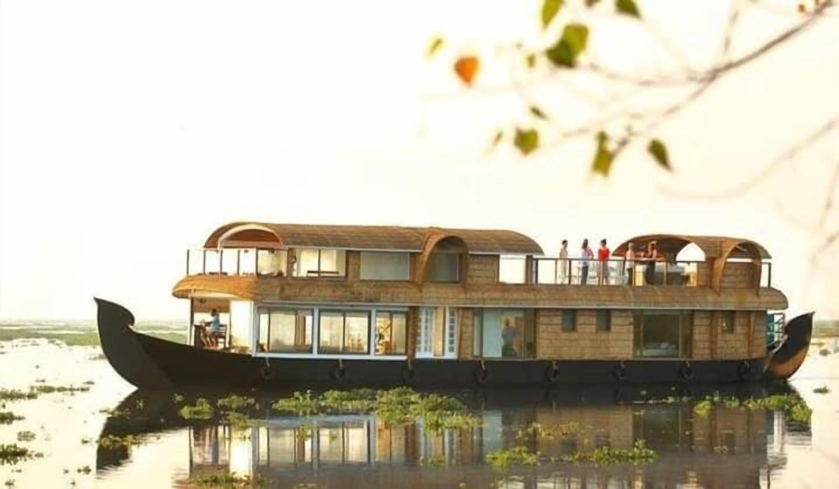 A houseboat with multiple levels, large windows, and a deck area.