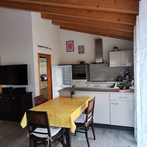 A compact kitchen with white cabinets, a built-in oven, and a microwave.