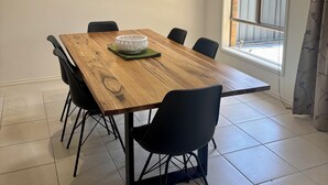 En matplats med ett träbord, svarta stolar och en vit skål.