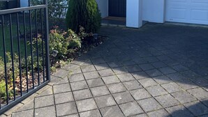 En bostadsfastighet med en asfalterad uppfart, en grind vid infarten och ett garage.