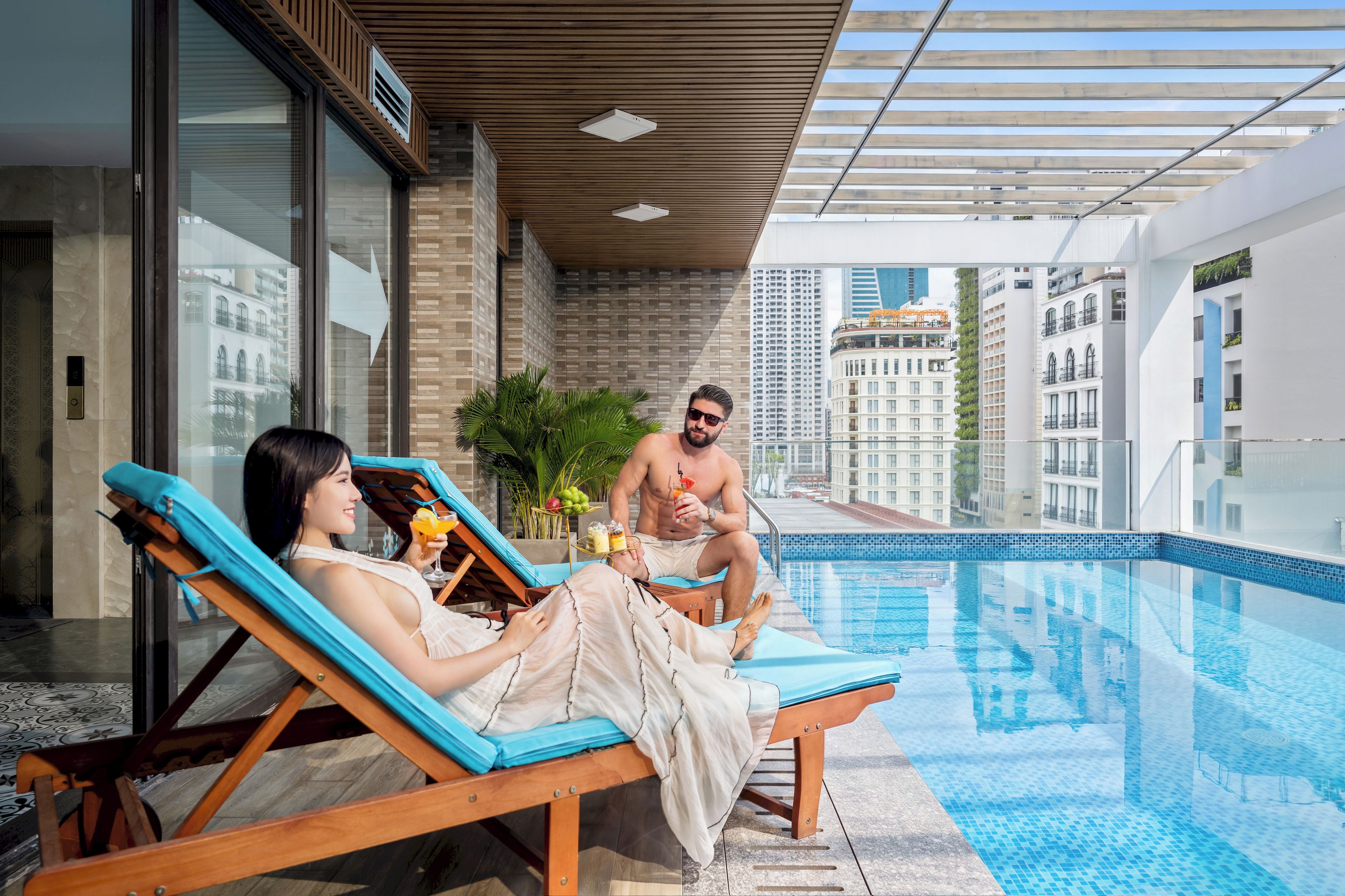 A poolside area with lounge chairs, a clear view of the cityscape, and a modern building facade.