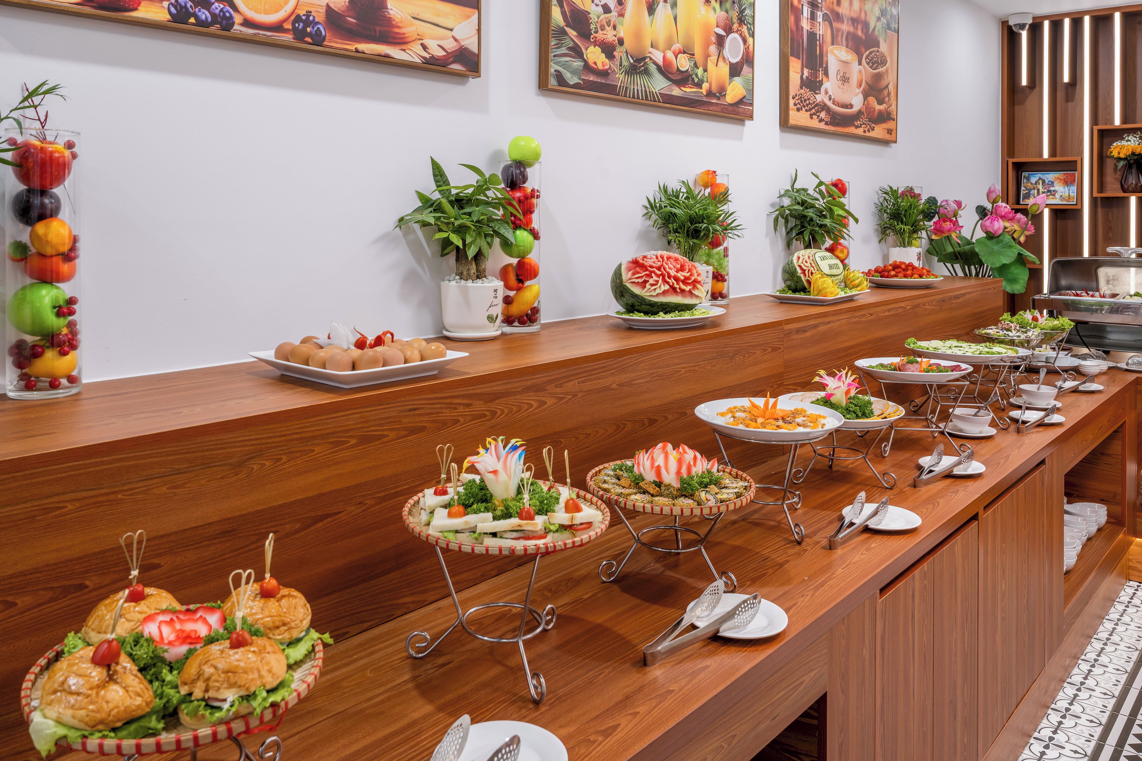 A buffet setup with various food items and a decorative plant arrangement.