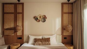 A hotel room with a large bed, two wooden nightstands, a wall-mounted lamp, and a decorative wall piece.