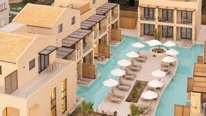 Un hôtel doté d’une piscine, de plusieurs espaces de détente agrémentés de parasols et d’une architecture moderne.
