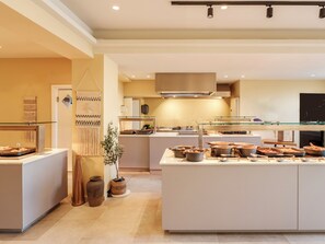 Een moderne keuken met een centraal eiland, een hanglamp en een wandfornuis.