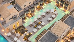 Vue aérienne d’un hôtel doté d’une piscine, d’espaces de détente et de sièges en plein air.