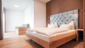 Een moderne slaapkamer met een groot bed, een houten hoofdbord en een nachtkastje.