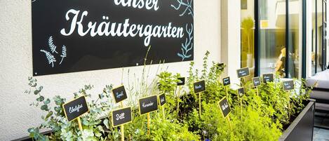 Un letrero que dice 'Unser Kräutergarten' con varias etiquetas de hierbas.
