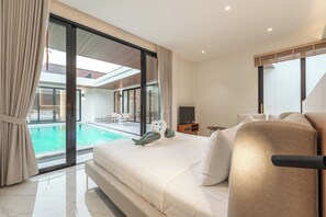 Une chambre d’hôtel moderne dotée d’un grand lit, d’une télévision et offrant une vue sur une piscine extérieure.