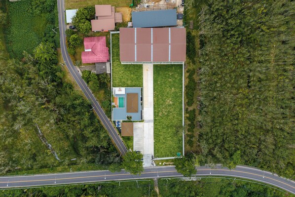 Une vue aérienne d’une propriété comprenant un grand bâtiment, une construction plus petite et une route.