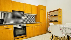 Une cuisine avec des meubles de rangement en bois, une cuisinière et une table à manger avec des chaises.