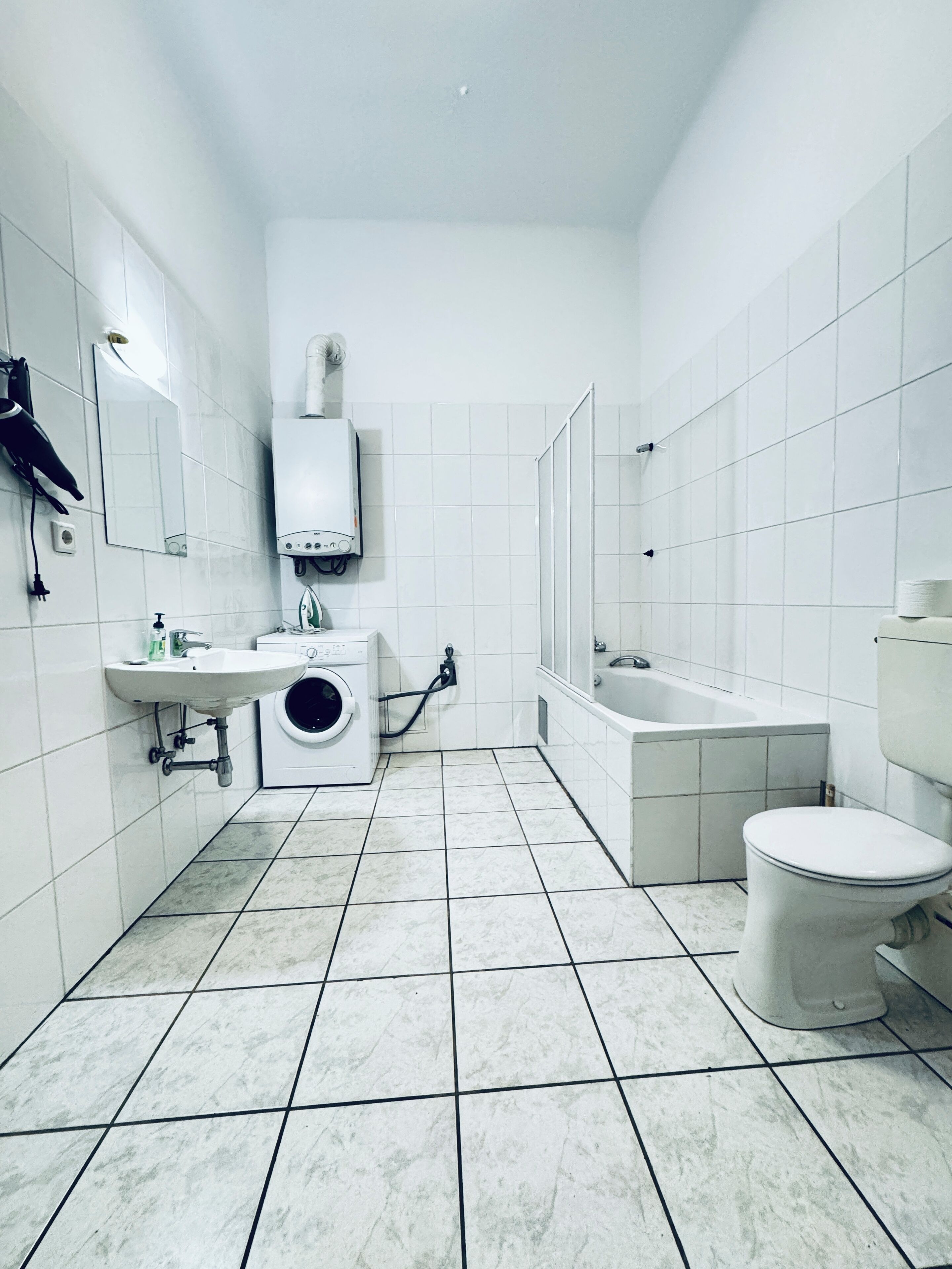 Eenvoudig appartement | Badkamer | Een bad/douchecombinatie, gratis toiletartikelen, een haardroger