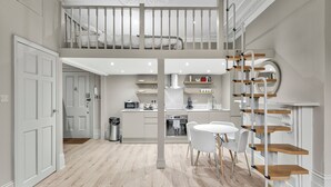 Een modern interieur met een eethoek, keuken en een slaapverdieping.