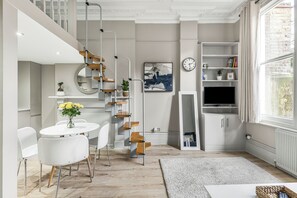 Un espace de vie moderne comprenant un escalier, un coin repas et une grande fenêtre.