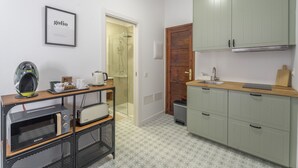 A compact kitchen with a microwave, toaster, and a small coffee maker on a wooden shelf. - Vacation Studio 'Tagoro' with Wi-Fi (Guía de Isora)