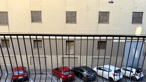 Eine Reihe geparkter Autos auf einem Parkplatz, im Hintergrund ein Gebäude.