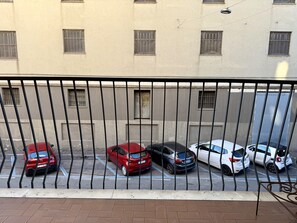 Eine Reihe geparkter Autos auf einem Parkplatz, im Hintergrund ein Gebäude.