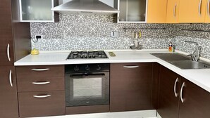 Eine Küche mit Gaskochfeld, Backofen und Spüle aus Edelstahl.