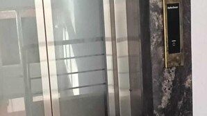 En elevator med en metal dør og et kontrolpanel på væggen.