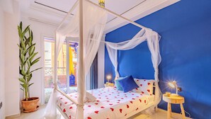 A room with a four-poster bed, a potted plant, and a nightstand with a lamp. - Boho chic retreat (Marrakech)