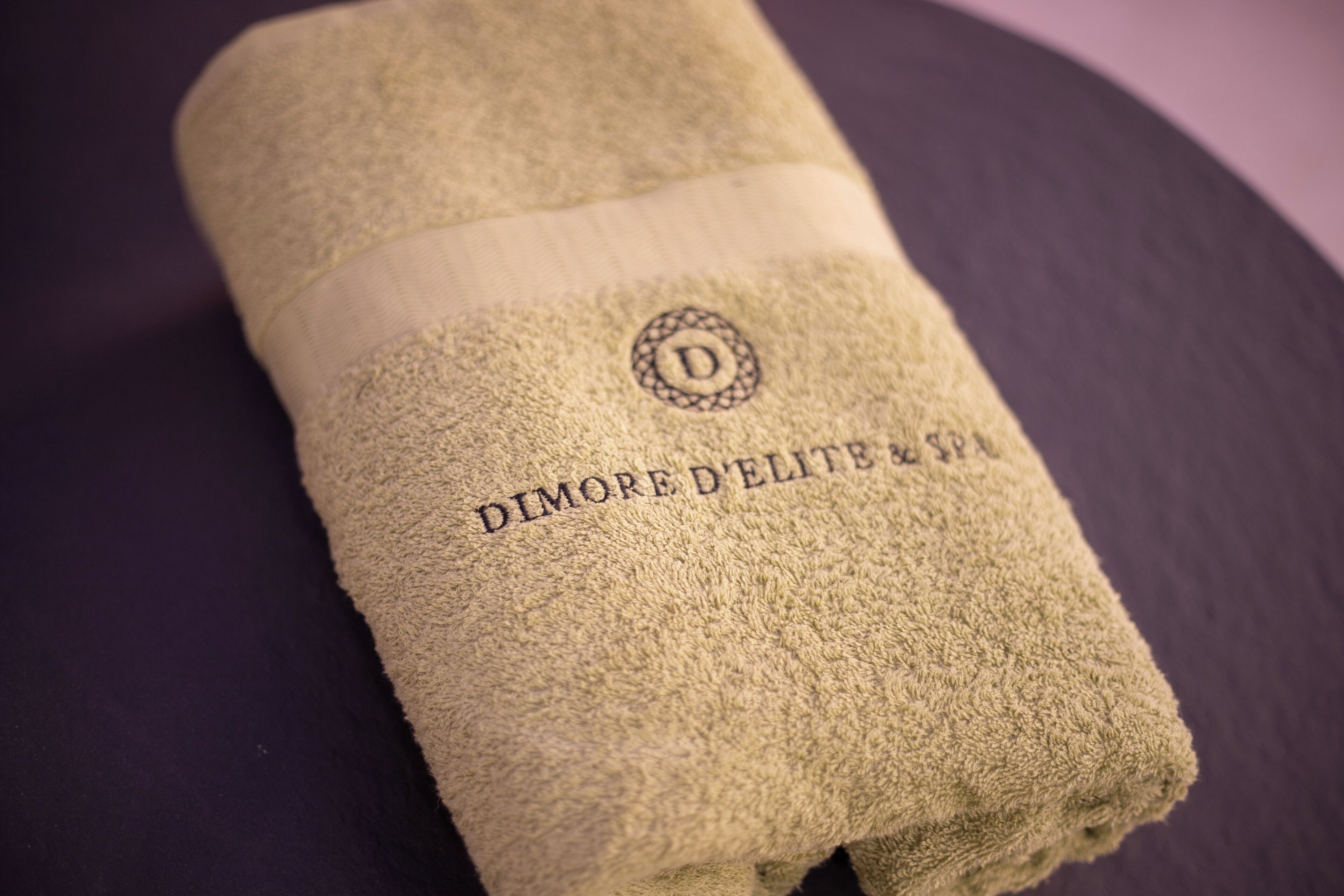 Una toalla doblada con el texto 'DIMORE D'ELITE & SPA'.