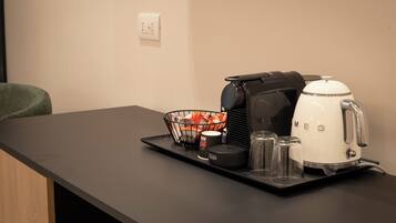 Minibar, escritorio, cortinas blackout y tabla de planchar con plancha