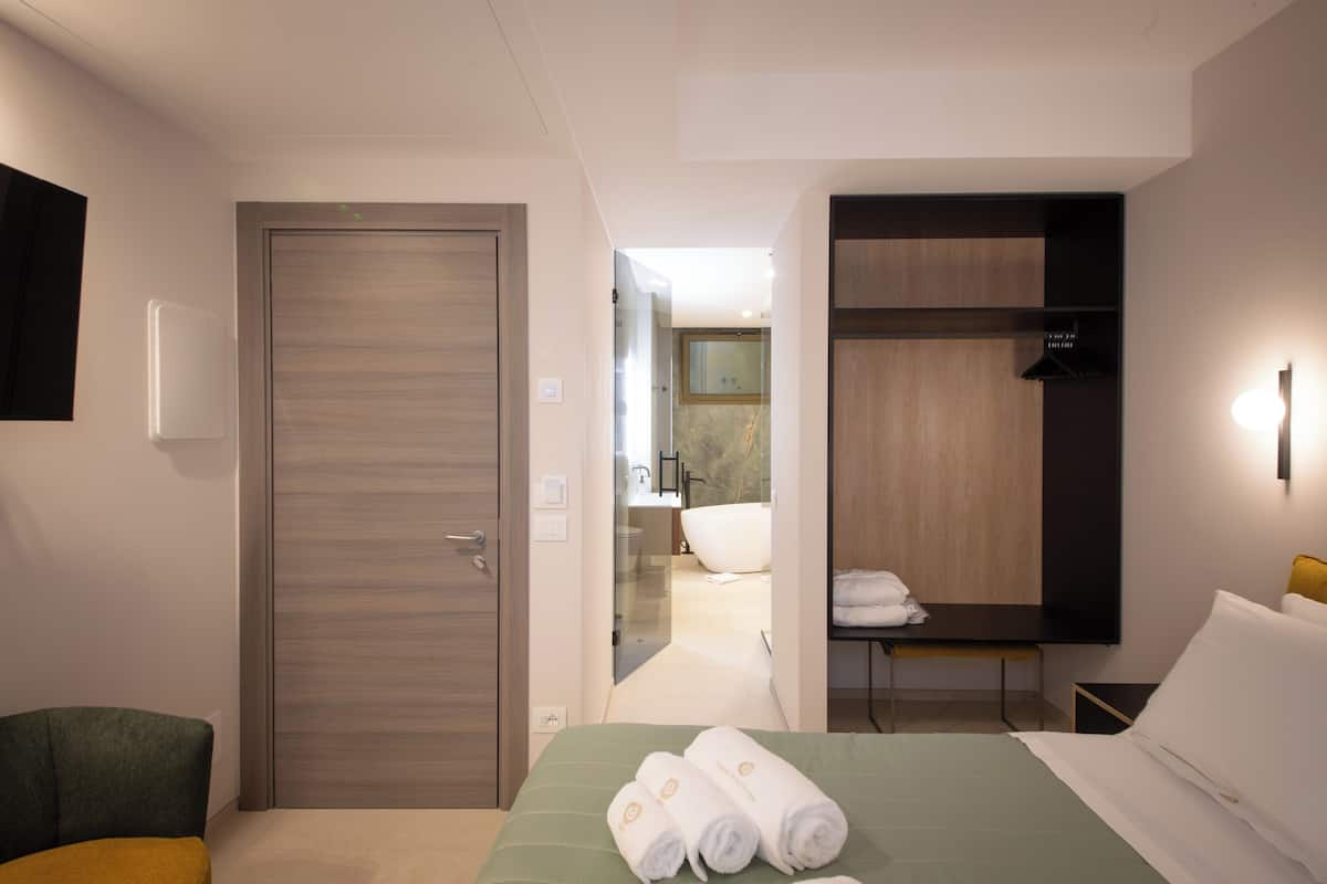 Minibar, escritorio, cortinas blackout y tabla de planchar con plancha