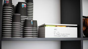 Una repisa con tazas a rayas negras y blancas y una caja blanca con texto.