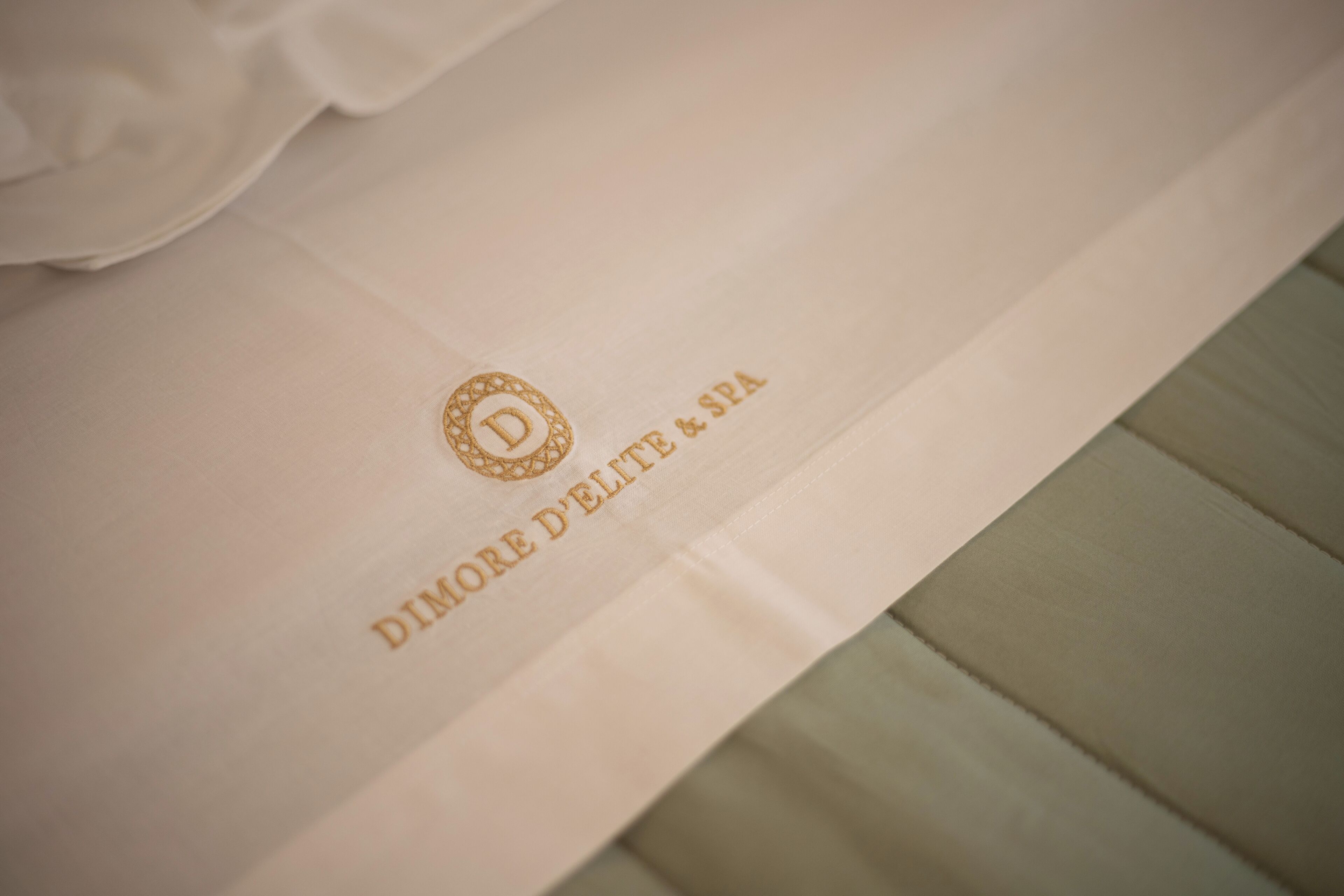 A white envelope with embossed text "DIMORE D'ELITE & SPA".