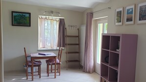A room with a wooden desk, two chairs, a bookshelf, a window with curtains, and wall-mounted hooks. - Cozy La Lavanda Studio Apartment with private terrace and infinity pool (Merana)