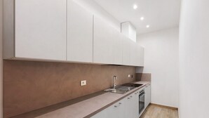 Een moderne keuken met een ingebouwde oven, een spoelbak en een aanrecht.