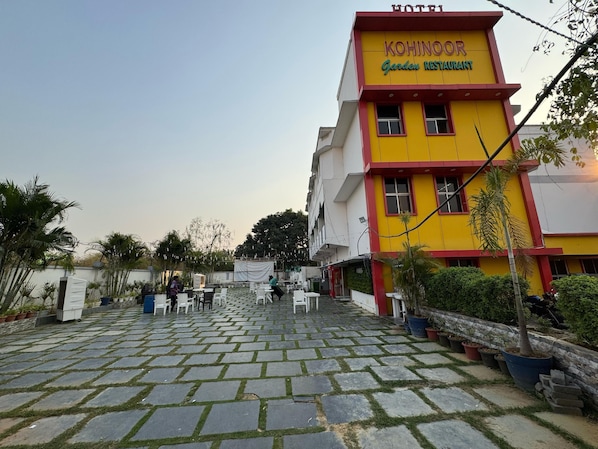 A hotel named "Kohinoor Garden Restaurant" with a paved courtyard and potted plants.