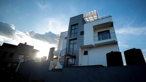 Ein modernes Gebäude mit flachem Dach, großen Fenstern und einem Balkon.