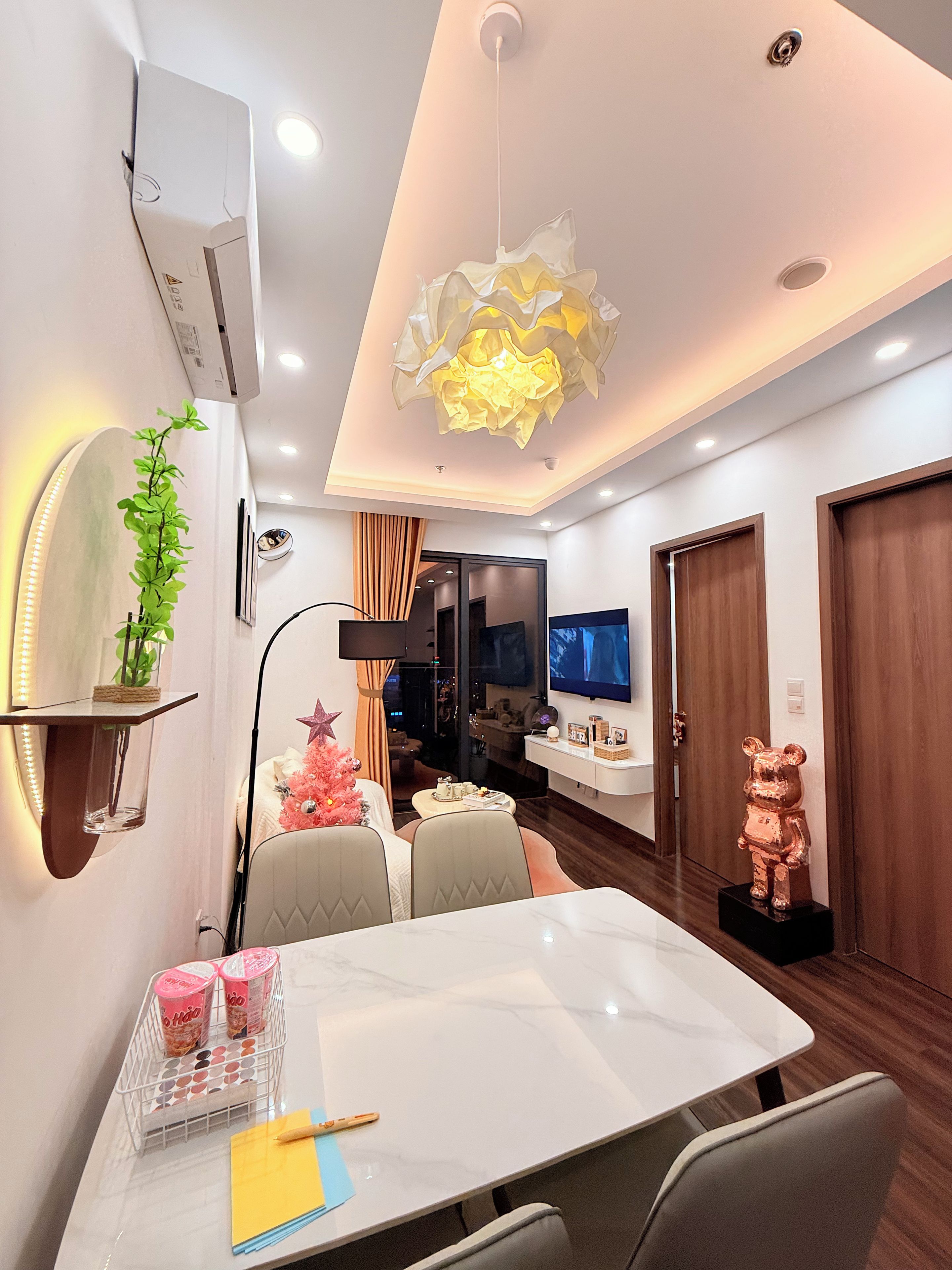 Un salon moderne comprenant un coin repas, un téléviseur et une statue d’ours décorative.