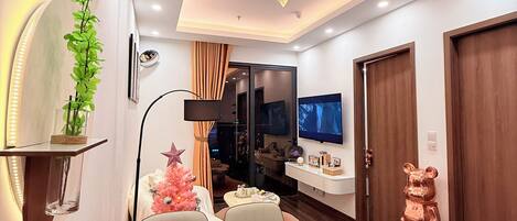 Un salon moderne comprenant un coin repas, un téléviseur et une statue d’ours décorative.