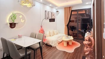 A modern living room with a dining area, a sofa, a coffee table, and a decorative statue.