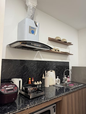 Eine moderne Küche mit Backofen, Dunstabzugshaube und Spüle aus Edelstahl.
