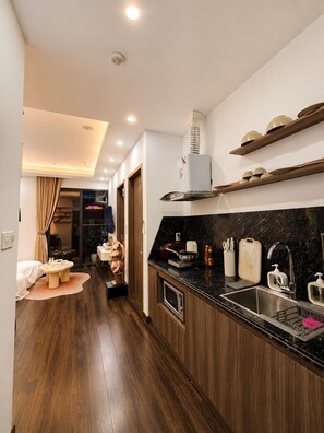 A modern kitchen with a built-in oven, a sink, and a stove. - X-Stay Sweet (Hai Phong)
