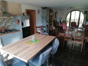 Eine Küche mit Holztisch, Stühlen und einem Essbereich mit großem Fenster.