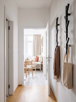 A hallway leading to a living area with a sofa, a table, and a patterned floor. - TurnKey | Florenc Apartment with Terrace II (Praha 8)