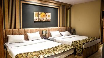 Habitación de hotel con dos camas, una obra de arte grande sobre el cabecero y paneles de madera decorando las paredes.