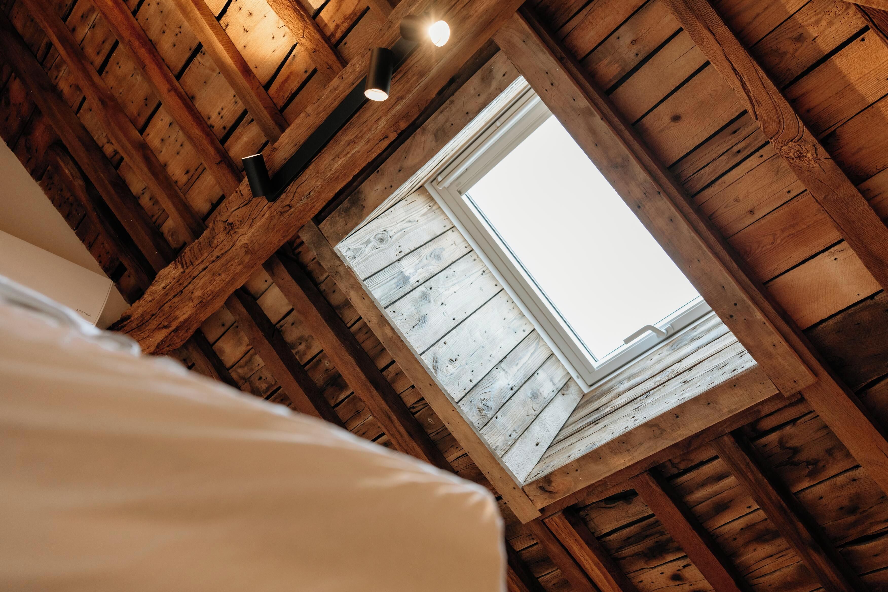 A room with wooden beams and a skylight.