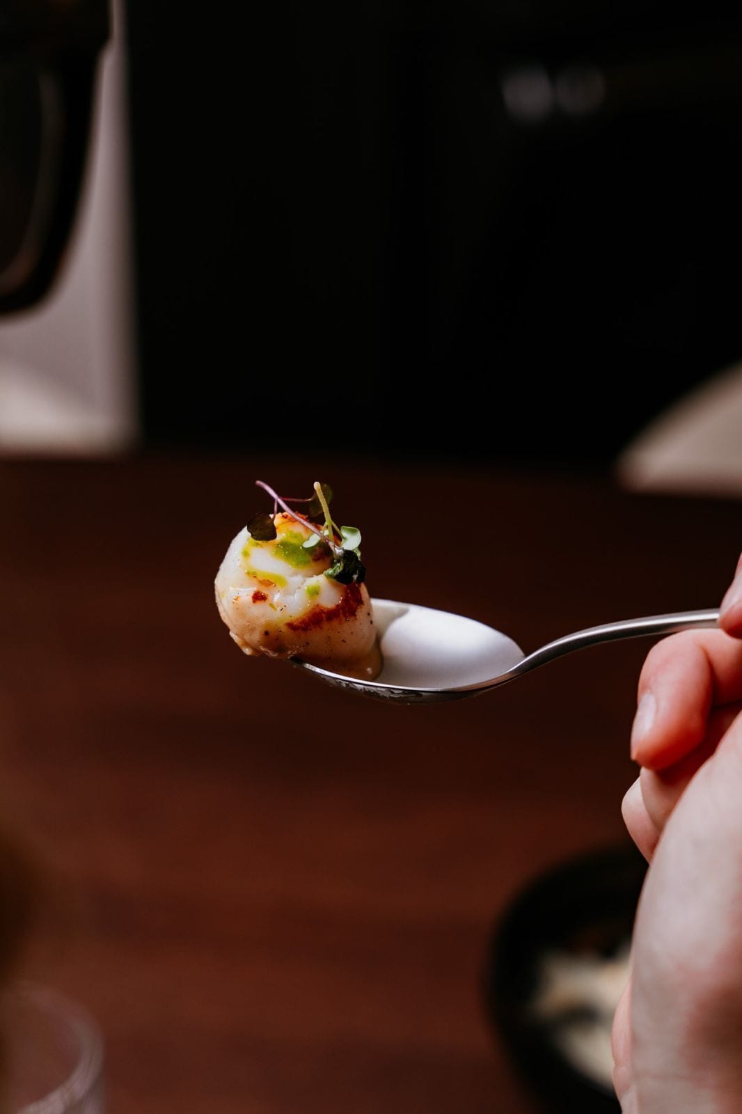 Una cuchara sosteniendo un alimento, posiblemente un postre.