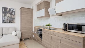Eine moderne Küche mit Holzschränken, einem eingebauten Geschirrspüler, einer Mikrowelle und einem Spülbecken.