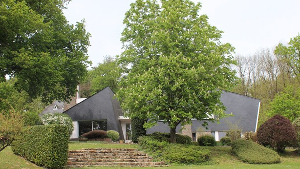 A modern house with a grey roof, surrounded by well-maintained lawns and hedges. - La Maison de l'Orbière - Suite (Forcé)