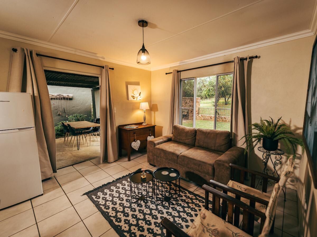 A cozy living room with a sofa, a dining table, and a small kitchen area.
