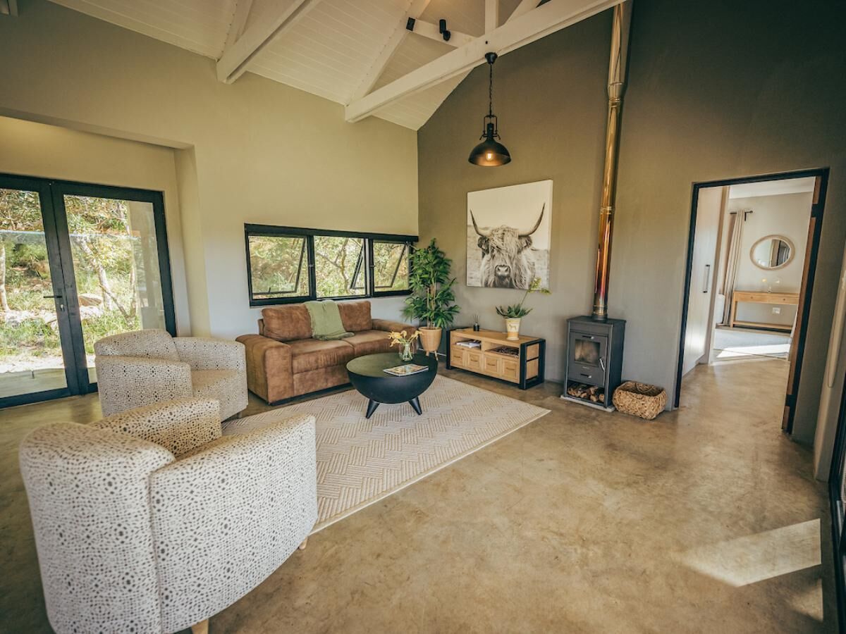 A spacious living room with a large window, a sofa, a coffee table, and a fireplace.
