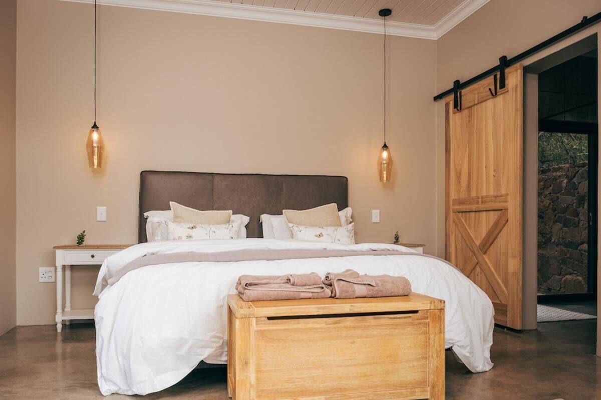 Ein Schlafzimmer mit einem großen Bett, einem Holzkopfende, Nachttischen und einer Holzbank.