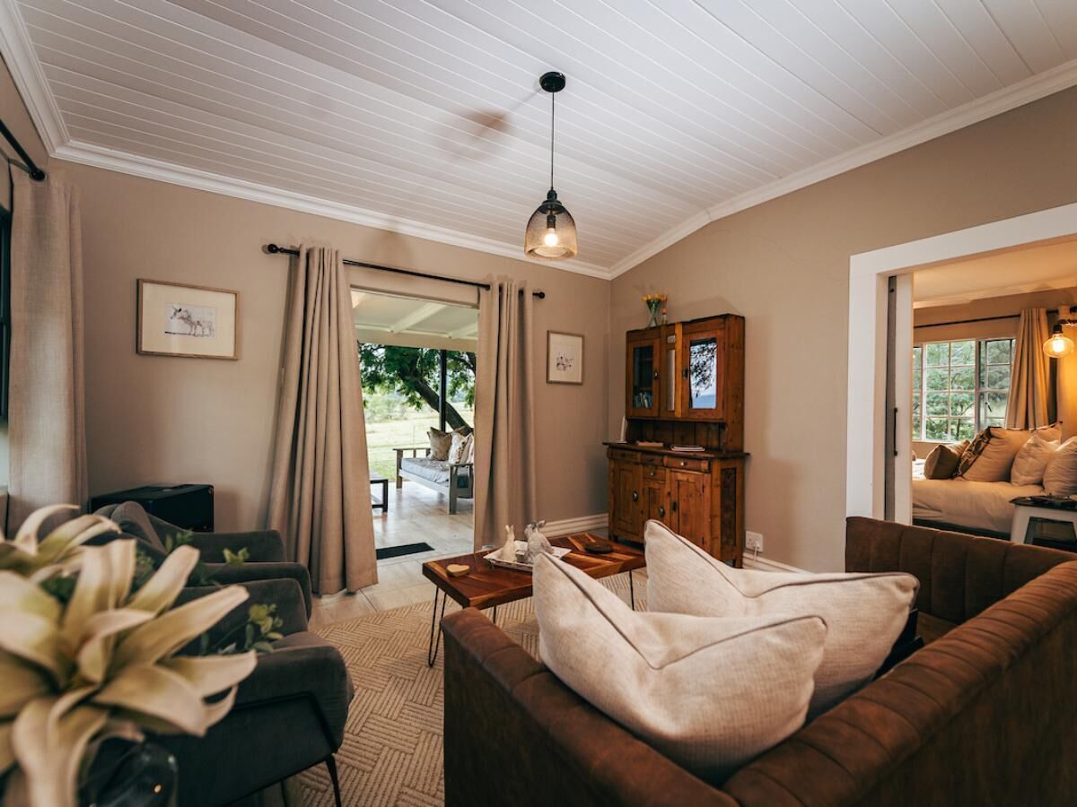 A cozy living room with a sofa, a wooden cabinet, and a hanging light fixture.