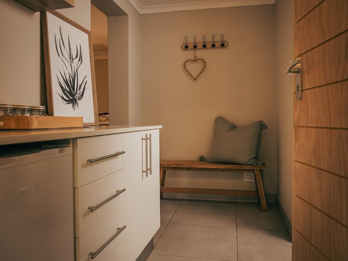 Eine Küche mit weißen Schränken, einer Holz Arbeitsplatte und einer Bank mit einer herzförmigen Dekoration.